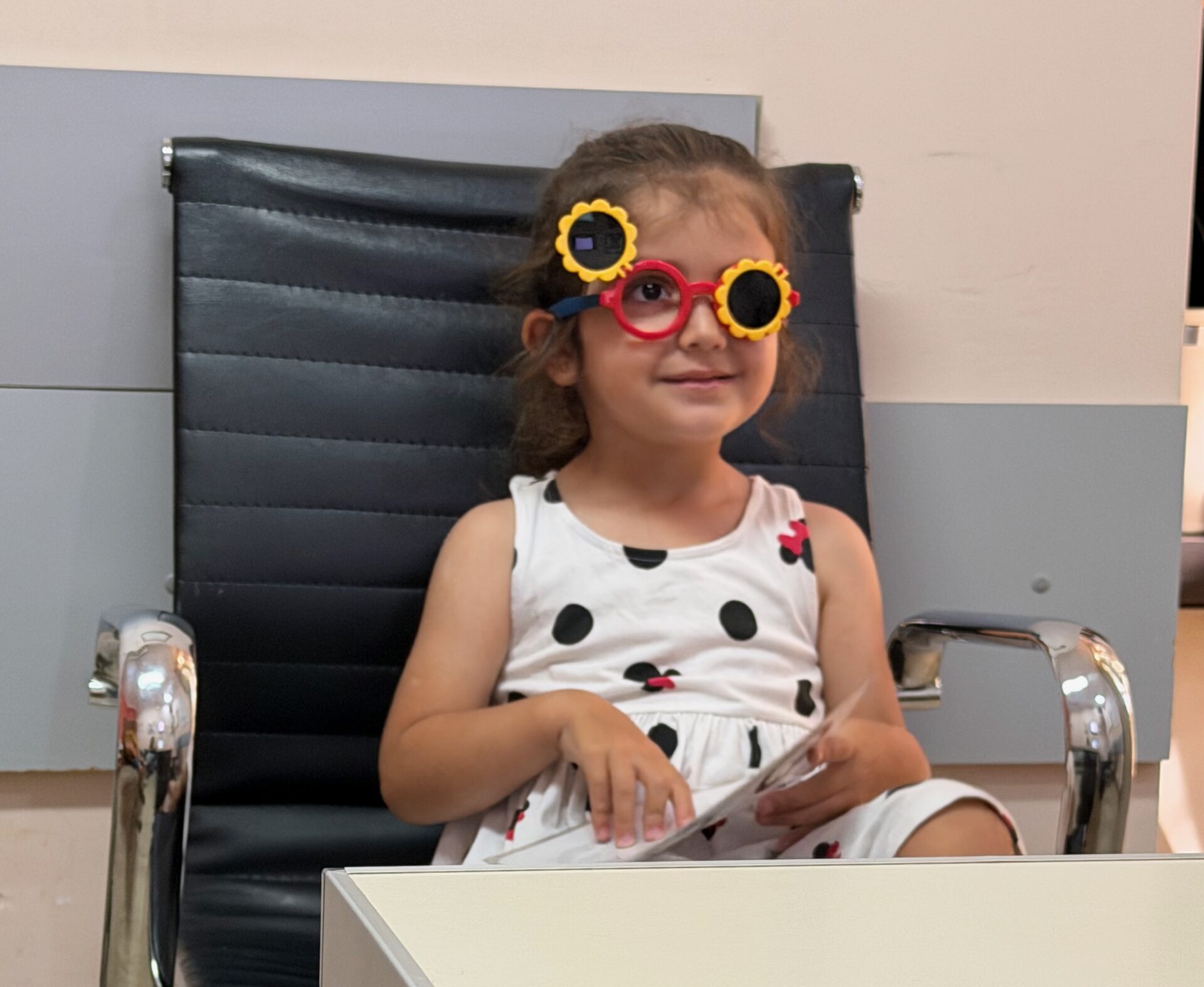 Niña con antiparras de girasol en consulta pediátrica